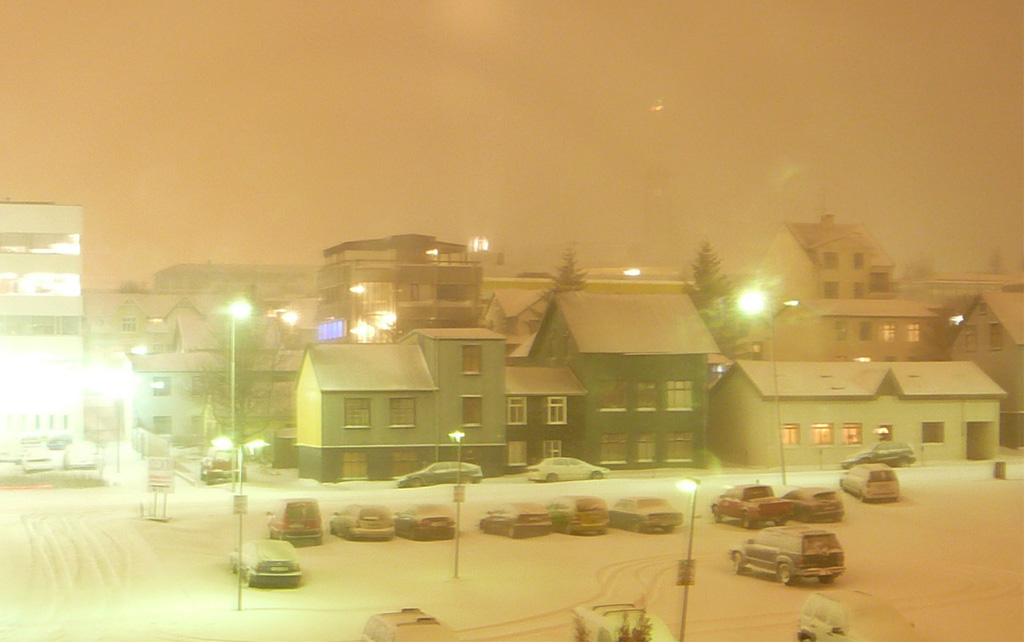 Snow covered buildings and cars in Reykjavík