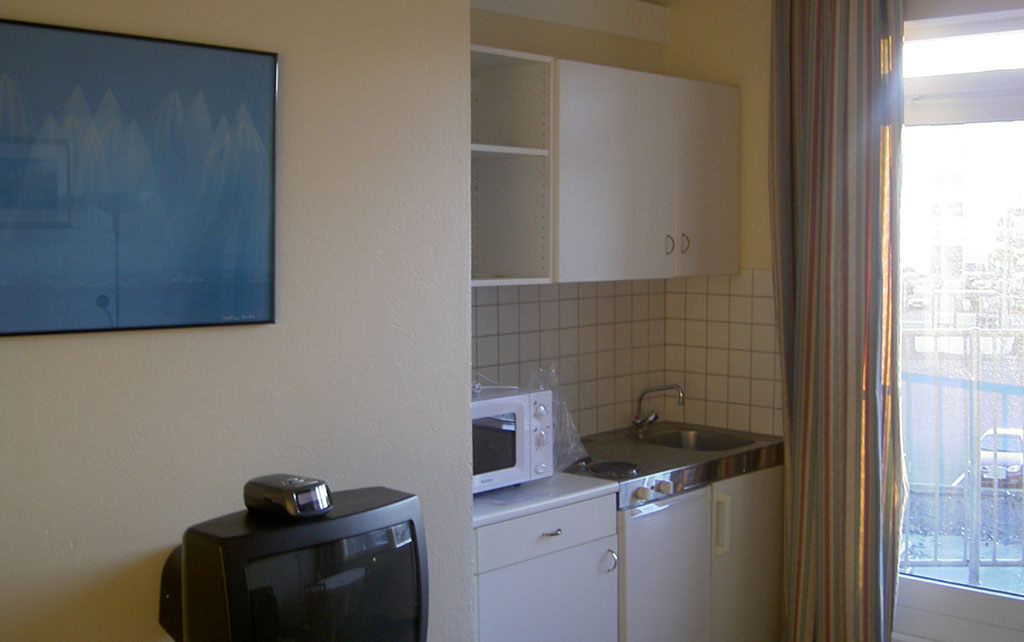 Icelandic hotel room kitchen with white tiles and cupboards